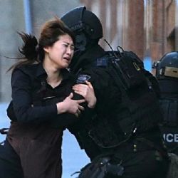 
Symbol tragédie v Sydney – plačící rukojmí v náručí policisty
